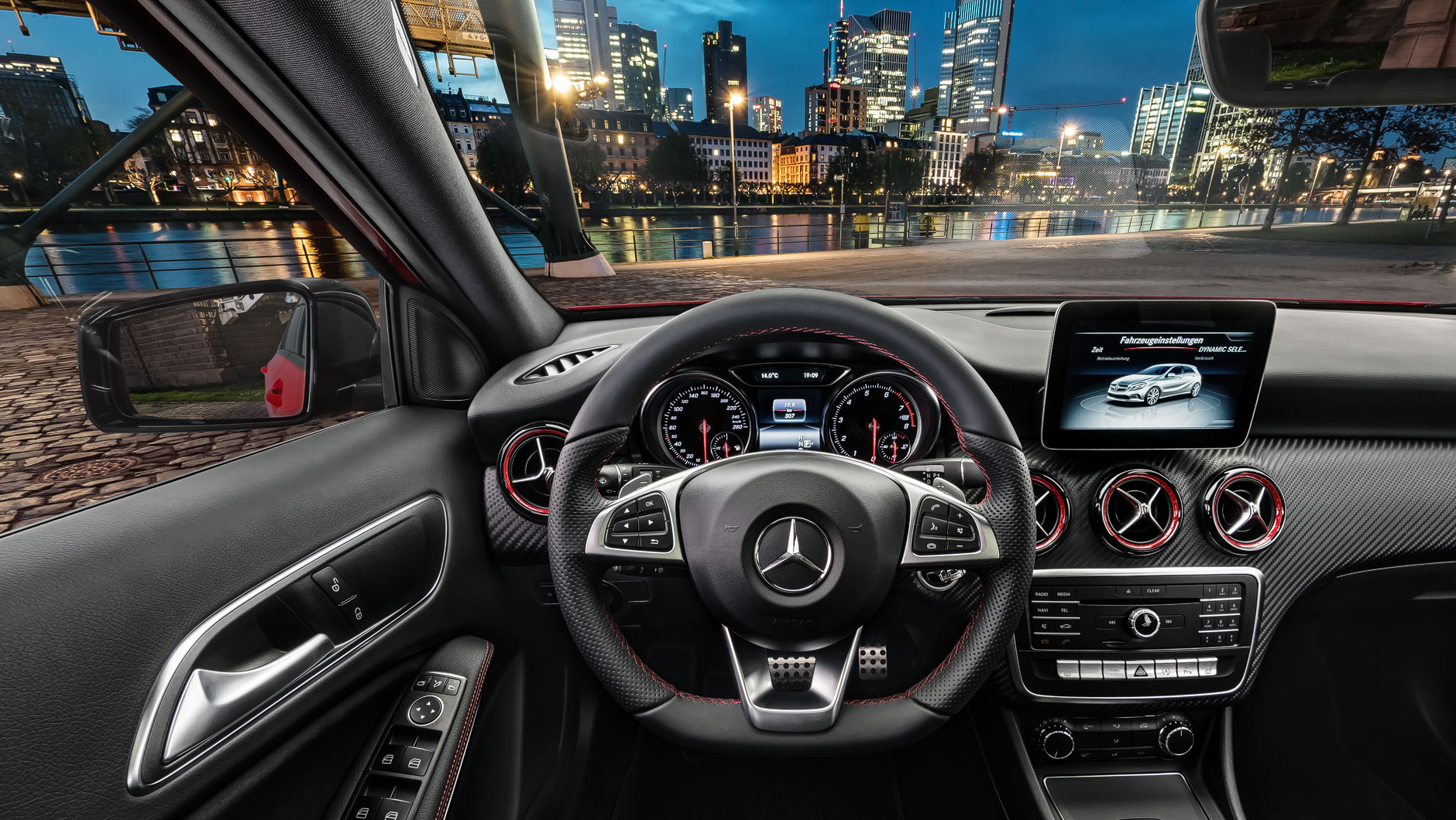 Autoinnenraum / Interior einer Mercedes-Benz A-Klasse. Bild aufgenommen aus der Perspektive des Fahrers. Das Fahrzeug steht am Mainufer in Frankfurt bei Nacht.